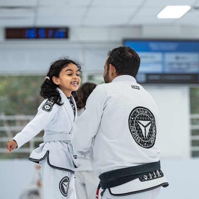 Young girl smiling with her coach at SJJA Hornsby kids class